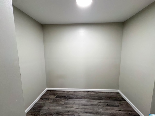 spare room with dark wood-type flooring and baseboards