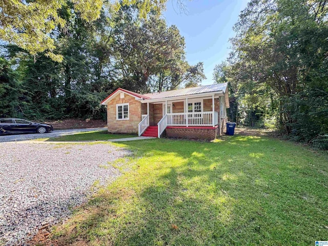 single story home featuring metal roof, a porch, and a front yard