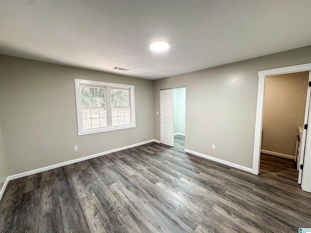 unfurnished bedroom featuring dark hardwood / wood-style floors and a closet