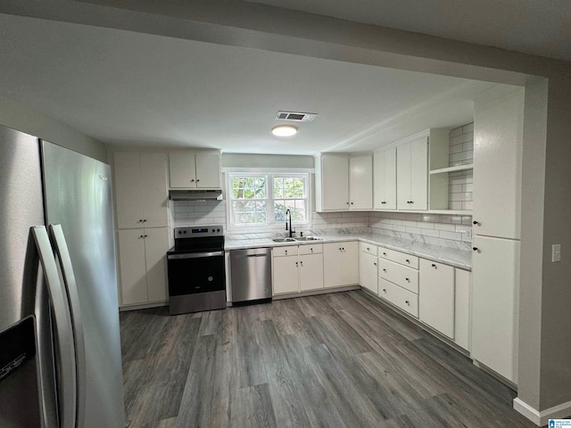 kitchen with tasteful backsplash, dark wood-type flooring, stainless steel appliances, sink, and white cabinets