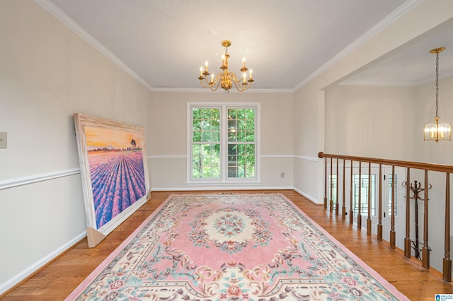 interior space with hardwood / wood-style flooring, an inviting chandelier, and crown molding