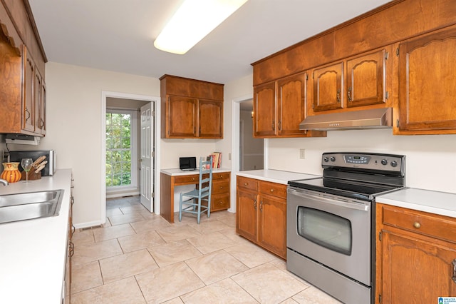 kitchen with stainless steel range with electric stovetop, sink, and light tile patterned flooring