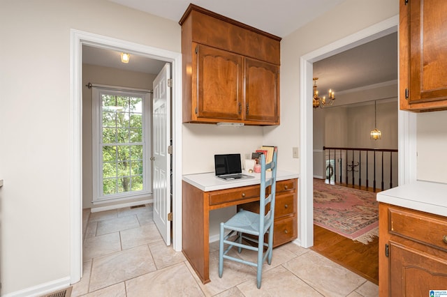 kitchen with crown molding, an inviting chandelier, decorative light fixtures, and light wood-type flooring