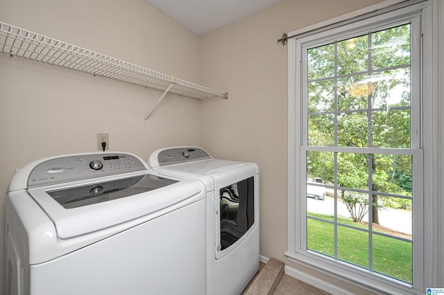 laundry area with light tile patterned floors and washer and clothes dryer