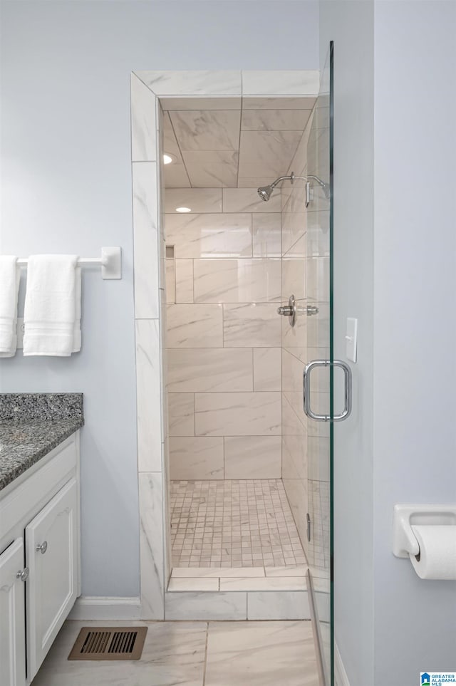 bathroom featuring tile patterned floors, walk in shower, and vanity