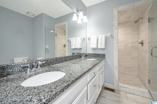 bathroom featuring tile patterned flooring, vanity, toilet, and an enclosed shower