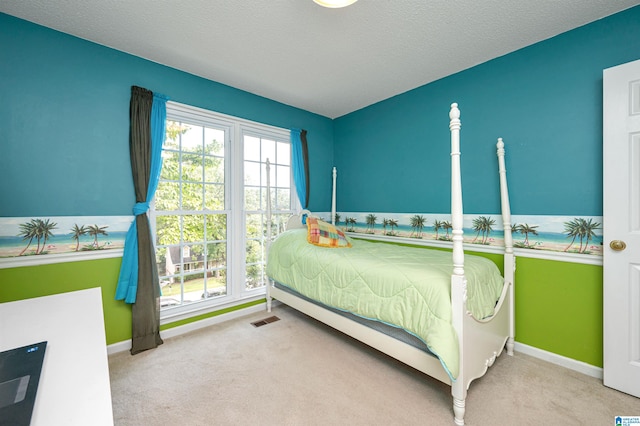 bedroom with a textured ceiling and light carpet