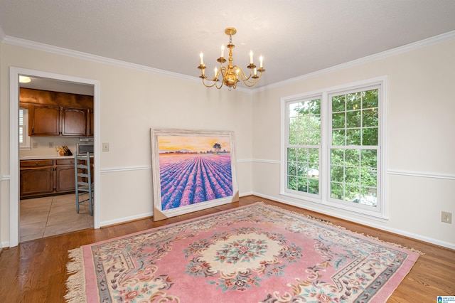 tiled spare room with a notable chandelier and ornamental molding