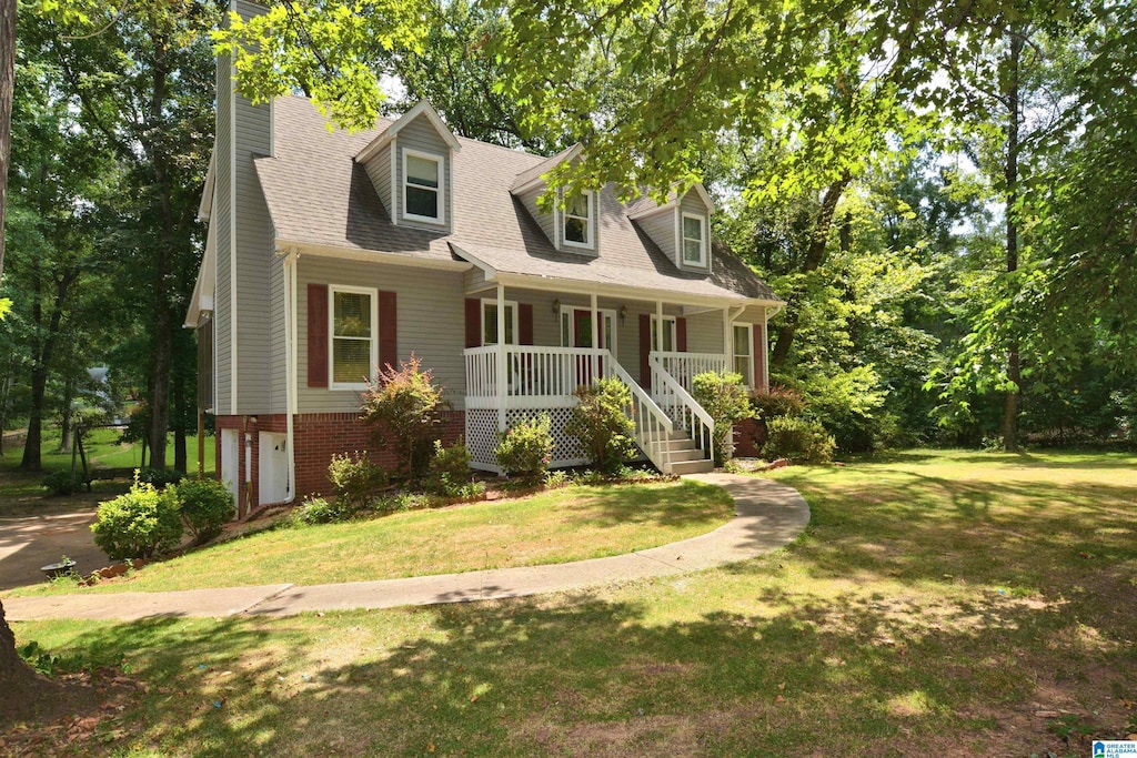 cape cod house with covered porch and a front lawn