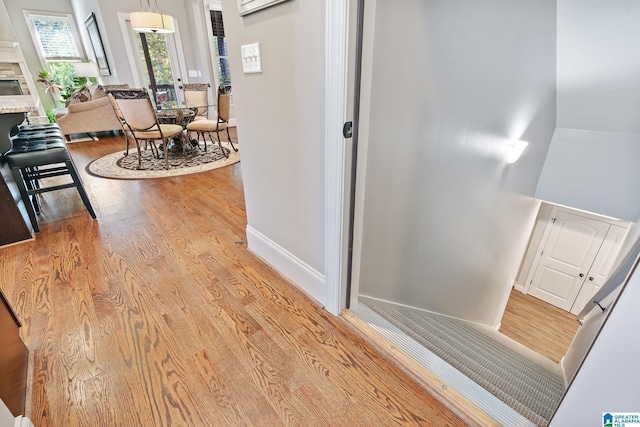 hall with light wood-style flooring and baseboards