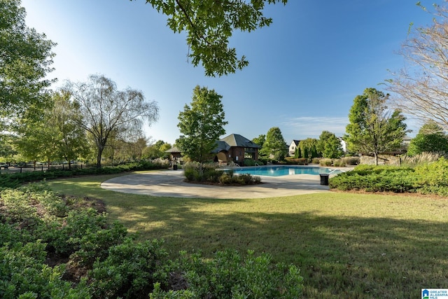 outdoor pool featuring a lawn