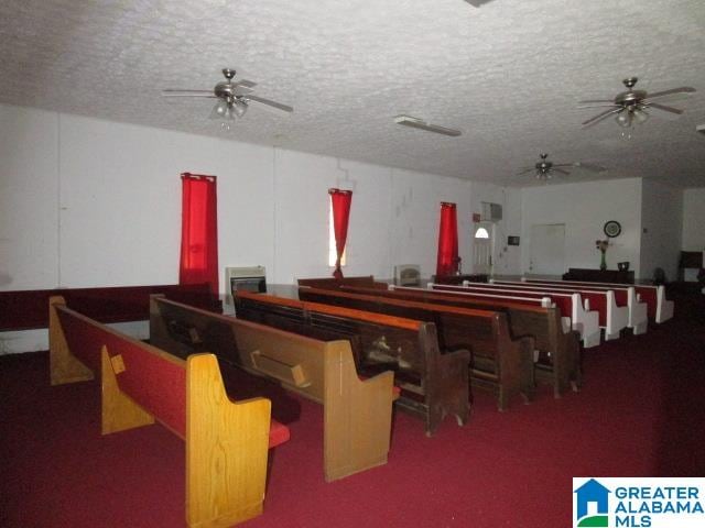 miscellaneous room featuring a textured ceiling, ceiling fan, and carpet