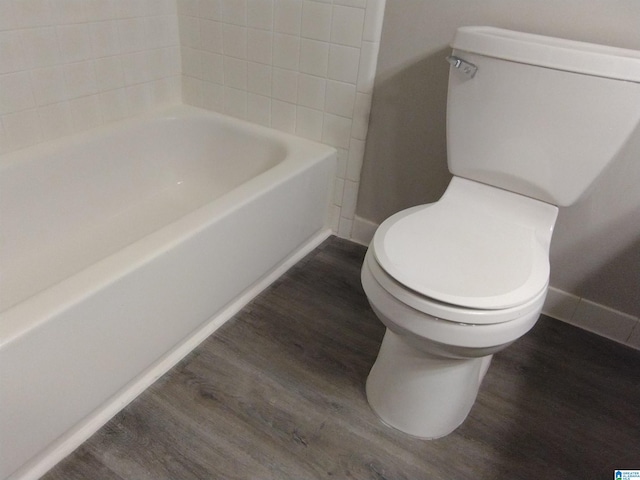 bathroom featuring toilet, a bathing tub, and wood-type flooring