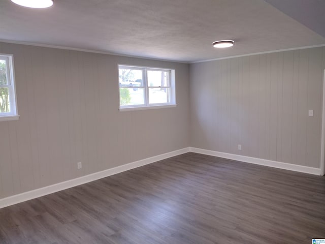 spare room with dark wood-type flooring and crown molding