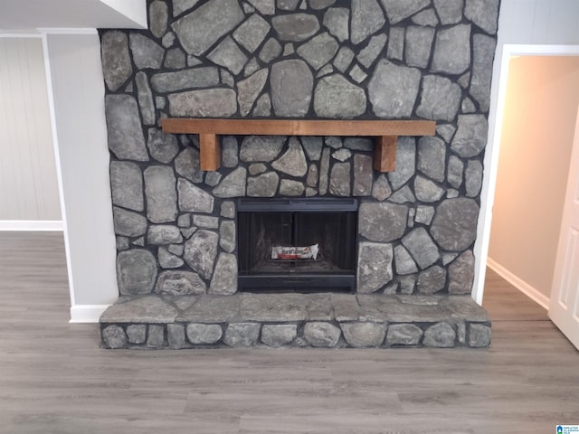 details featuring hardwood / wood-style flooring and a stone fireplace