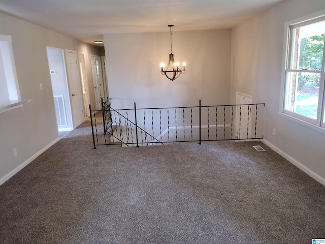 unfurnished room featuring carpet floors and an inviting chandelier