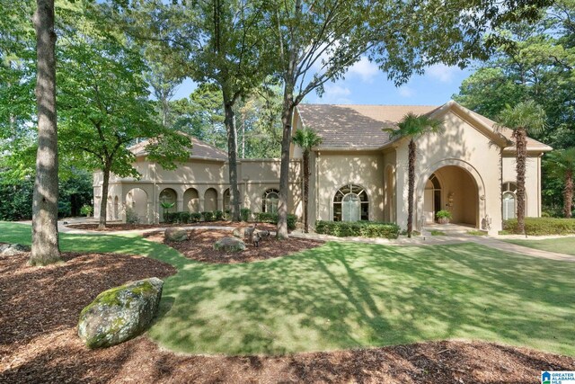 mediterranean / spanish house featuring a front lawn