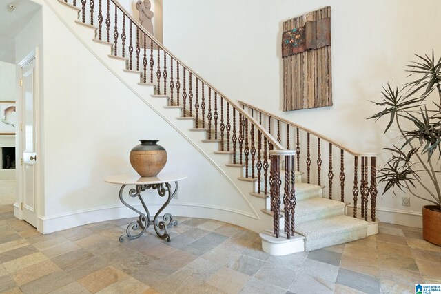 stairway with a high ceiling and tile patterned flooring