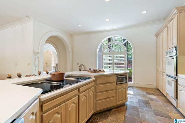 kitchen featuring dark tile patterned floors, black electric cooktop, ornamental molding, double oven, and light brown cabinetry