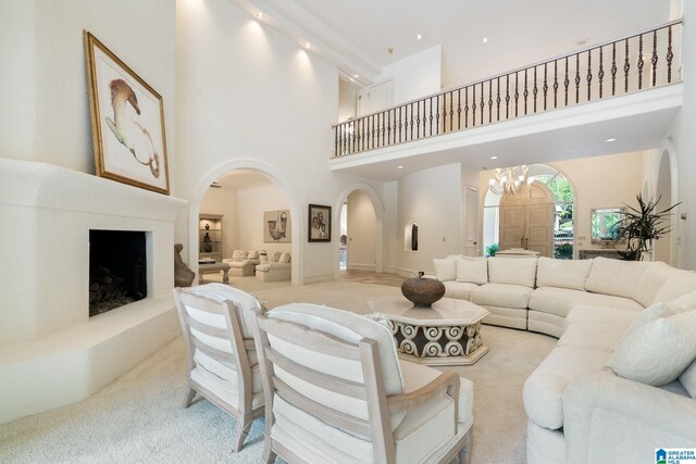 carpeted living room featuring a high ceiling and a chandelier