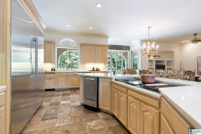 kitchen featuring light brown cabinets, ceiling fan with notable chandelier, dark tile patterned floors, and stainless steel appliances