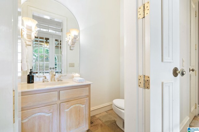 bathroom with toilet, tile patterned floors, and vanity