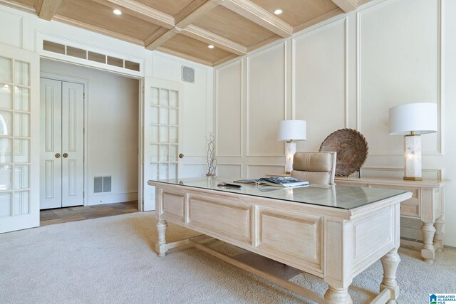 office space with wood ceiling, beam ceiling, light colored carpet, and coffered ceiling