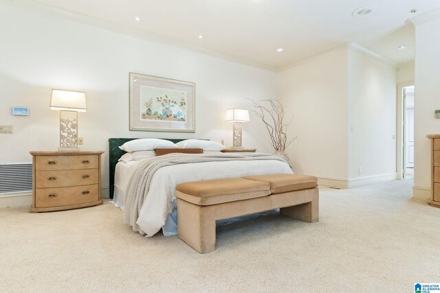 bedroom with ornamental molding and light colored carpet