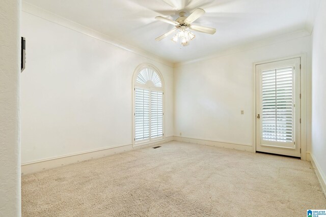 spare room featuring ceiling fan, light carpet, plenty of natural light, and crown molding