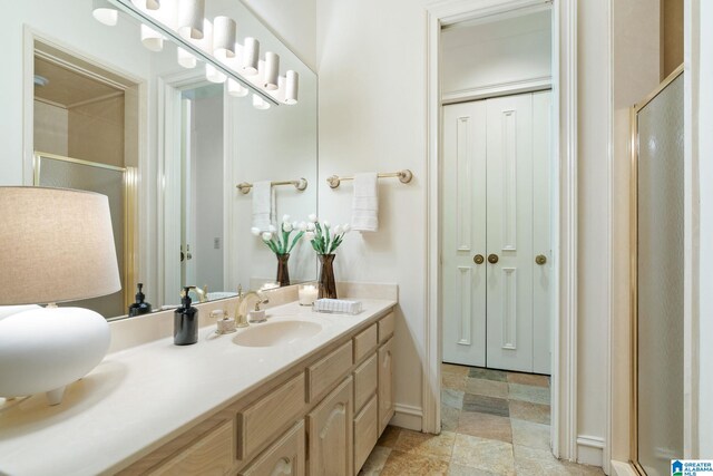 bathroom with tile patterned floors, vanity, and a shower with shower door