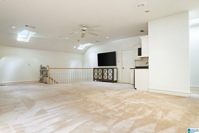 interior space featuring ceiling fan and vaulted ceiling with skylight