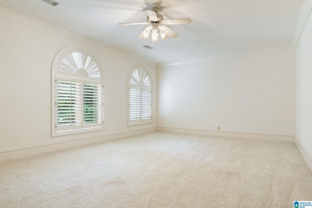 unfurnished room featuring ceiling fan, light carpet, and crown molding