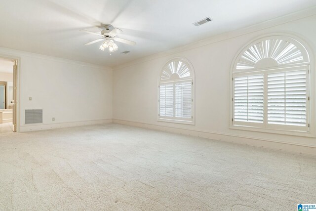 carpeted empty room with ceiling fan and ornamental molding