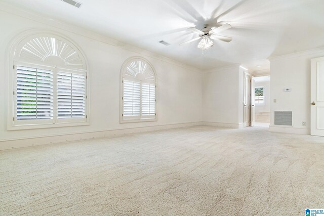 carpeted empty room featuring ceiling fan and crown molding