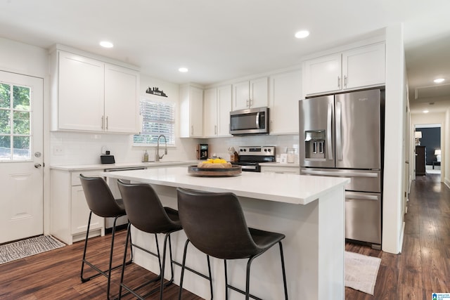 kitchen featuring white cabinets, appliances with stainless steel finishes, plenty of natural light, and dark hardwood / wood-style flooring