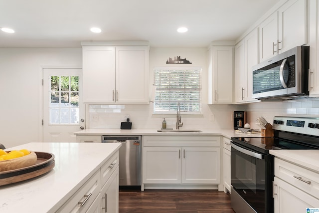 kitchen featuring dark wood-type flooring, sink, appliances with stainless steel finishes, and decorative backsplash