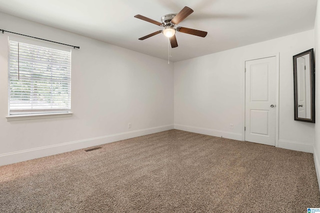 unfurnished room with ceiling fan and carpet