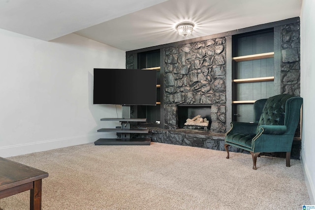 living room with carpet and a stone fireplace