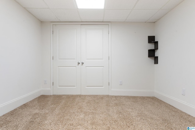 empty room with a paneled ceiling and carpet