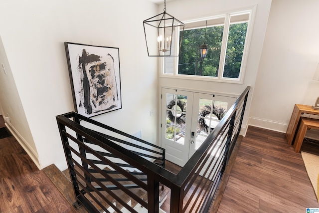 stairway featuring hardwood / wood-style flooring and a chandelier