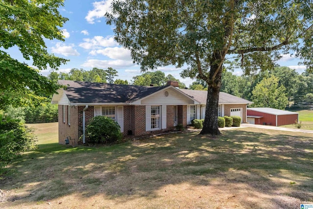 ranch-style home featuring a front yard, brick siding, a chimney, and an attached garage