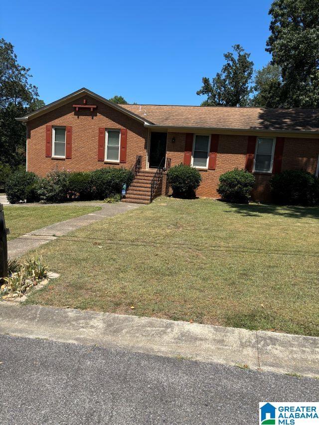 single story home featuring brick siding and a front yard