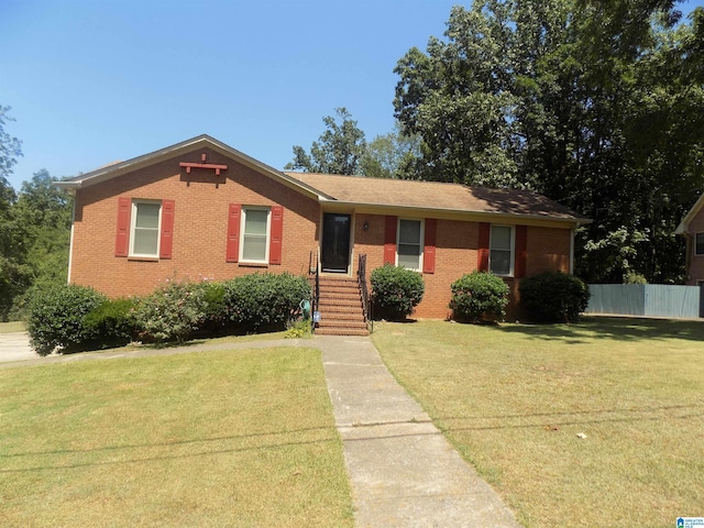 single story home with brick siding, fence, and a front lawn