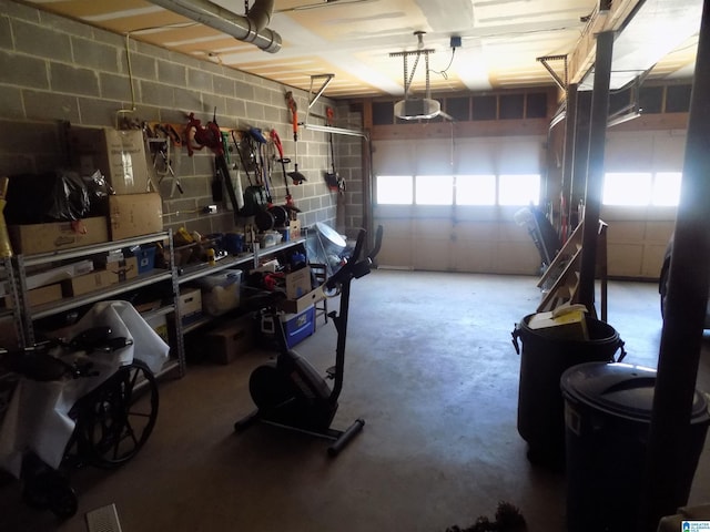 garage featuring concrete block wall and a garage door opener