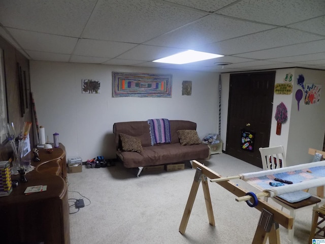 carpeted living room featuring a drop ceiling