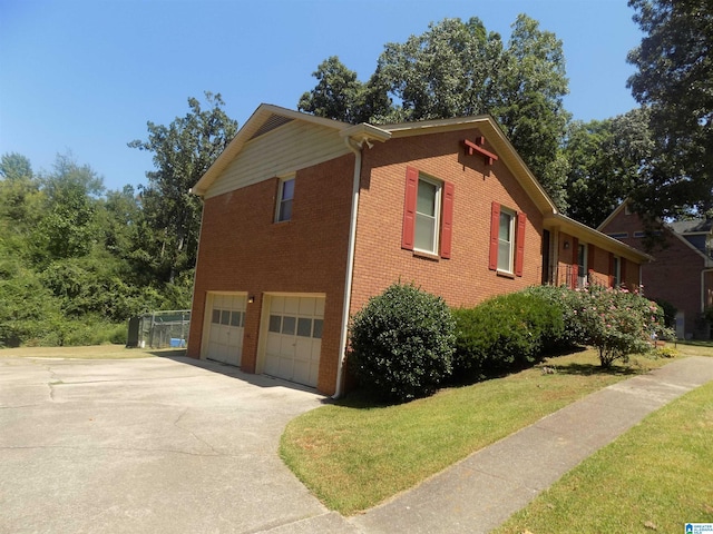 view of side of property featuring a garage, concrete driveway, brick siding, and a yard