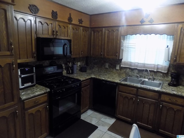 kitchen featuring light tile patterned floors, a textured ceiling, a sink, decorative backsplash, and black appliances