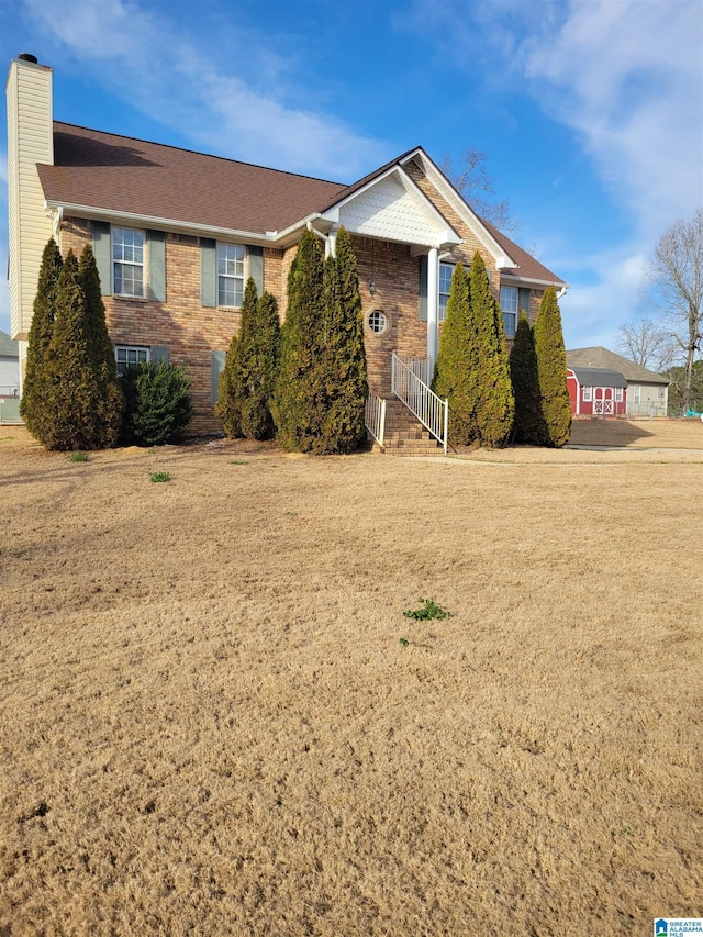 single story home with a front yard, brick siding, and a chimney