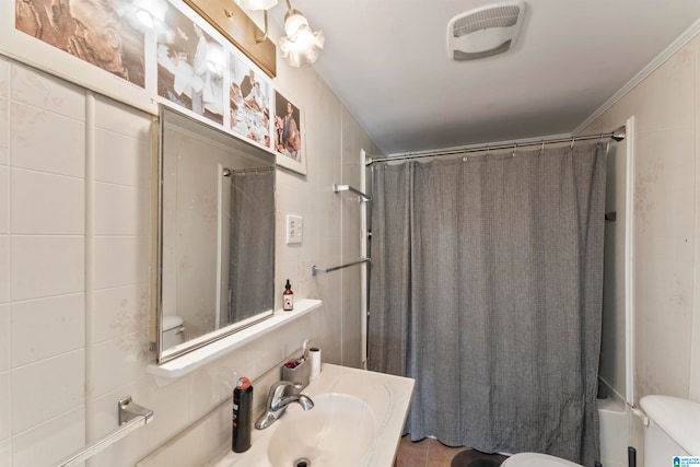 full bathroom with sink, crown molding, tile walls, toilet, and shower / bath combo