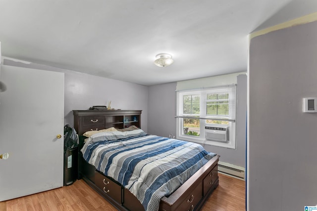 bedroom with a baseboard heating unit, light hardwood / wood-style flooring, and cooling unit